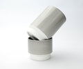 Two Asemi Hasami large cups in light grey stacked together, showing the soft glazed exterior and white base.