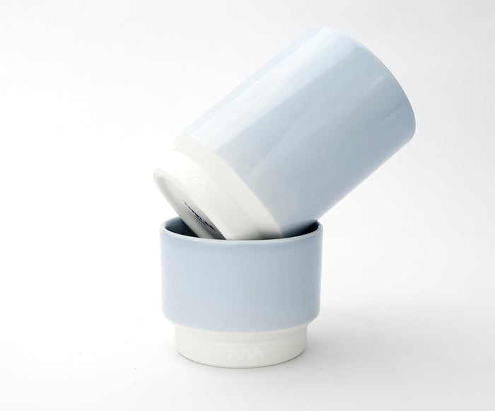 Two Asemi Hasami small cups in light blue stacked together, showing the soft glazed exterior and white base.