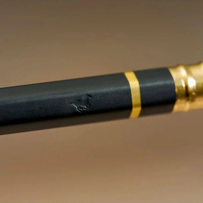 Angle view of a Blackwing Eras 2025 Edition pencil showing the matte black barrel and gold detailing.