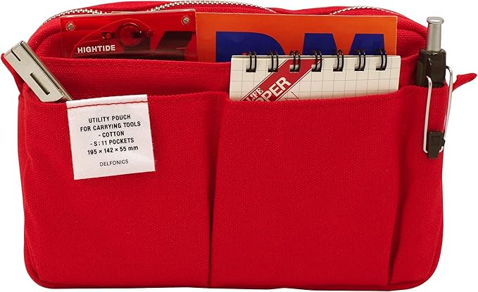 Front view of a red utility pouch displaying multiple external pockets filled with notebooks, pens, and tools.