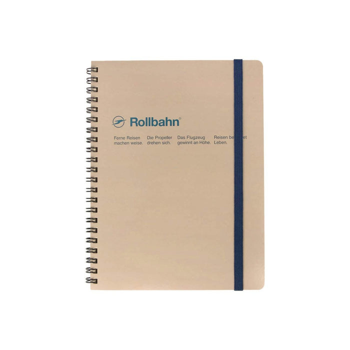 Greige Rollbahn spiral-bound notebook with navy blue elastic strap and minimalist text on the cover.
