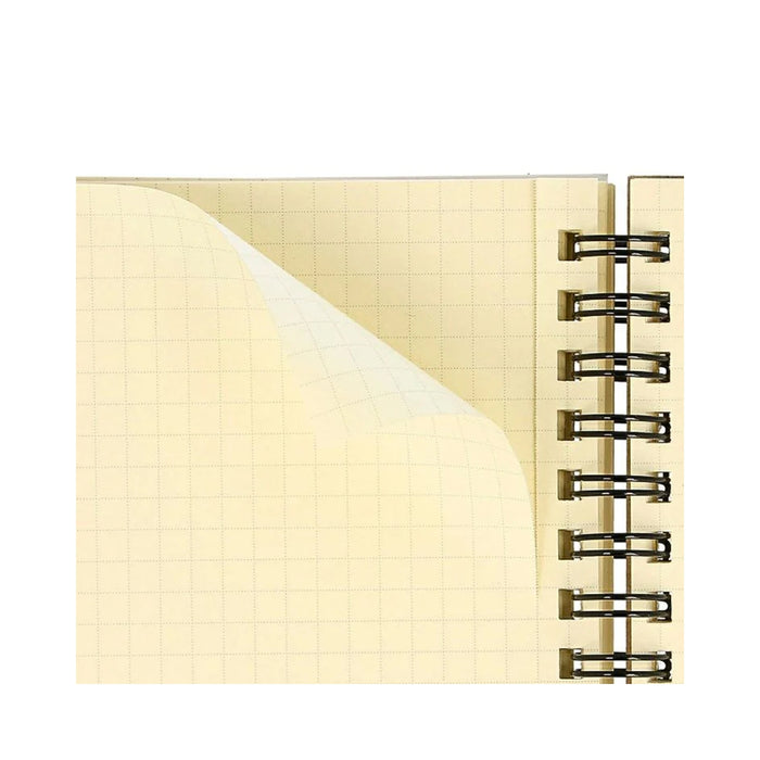A close-up of the inner grid paper in a mini Rollbahn notebook, showing cream pages with fine grey square grids.
