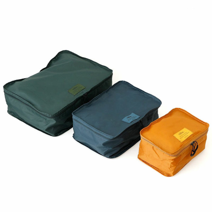 Three Nähe travel packing bags in green, blue, and orange, shown in different sizes.