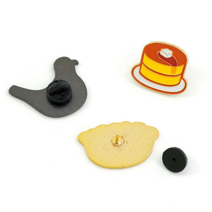 Rear view of bird and gyoza pins with clasps, shown alongside a pancake enamel pin.