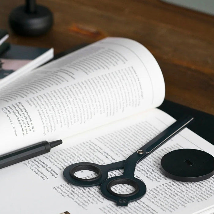 HMM Scissors Base aluminium stand in black used on workspace with notebook and tools nearby