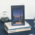 Iconic Daily Life Pocket Notebook v.3 lined edition displayed on a stack of books.