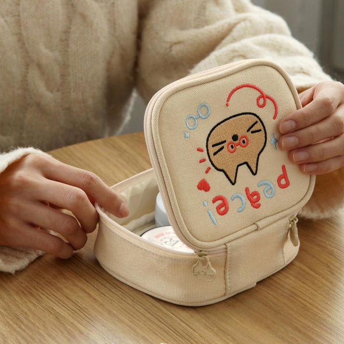 The Journal Shop - Person holding a cream Doodle Mini Pouch with a cat illustration and “Peace” doodles printed on the cover.