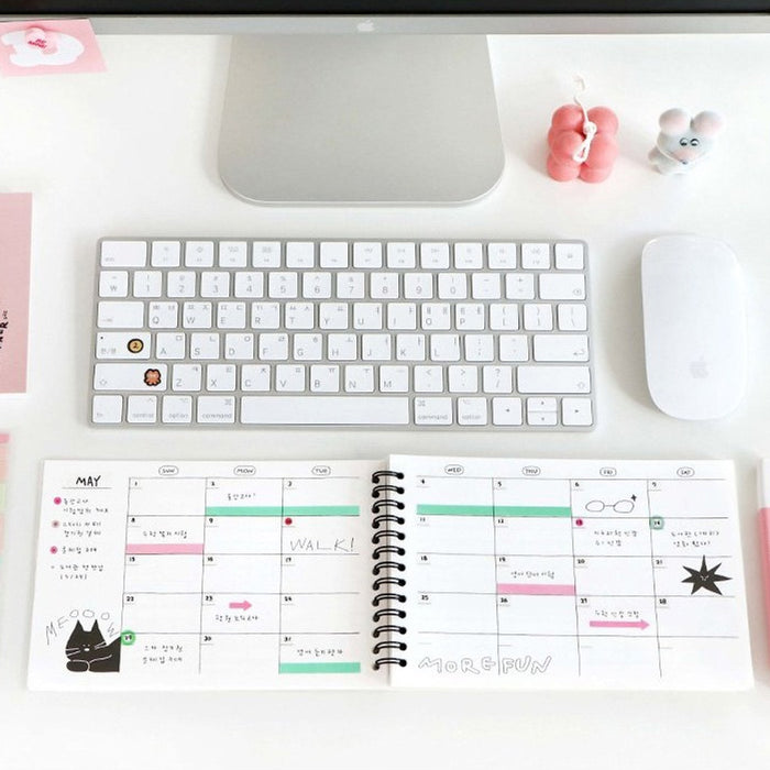 The Journal Shop - Open Doodle Study Planner on a desk beside a keyboard, pens, and sticky notes used for daily planning.