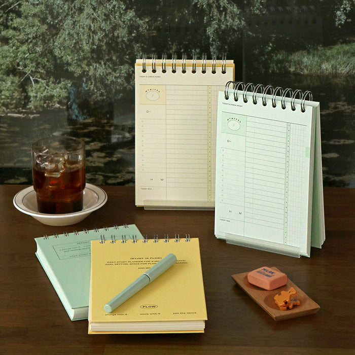 The Journal Shop - Iconic Flow B6 Spiral Study Planners in butter yellow and vintage green covers displayed together with pens and books.