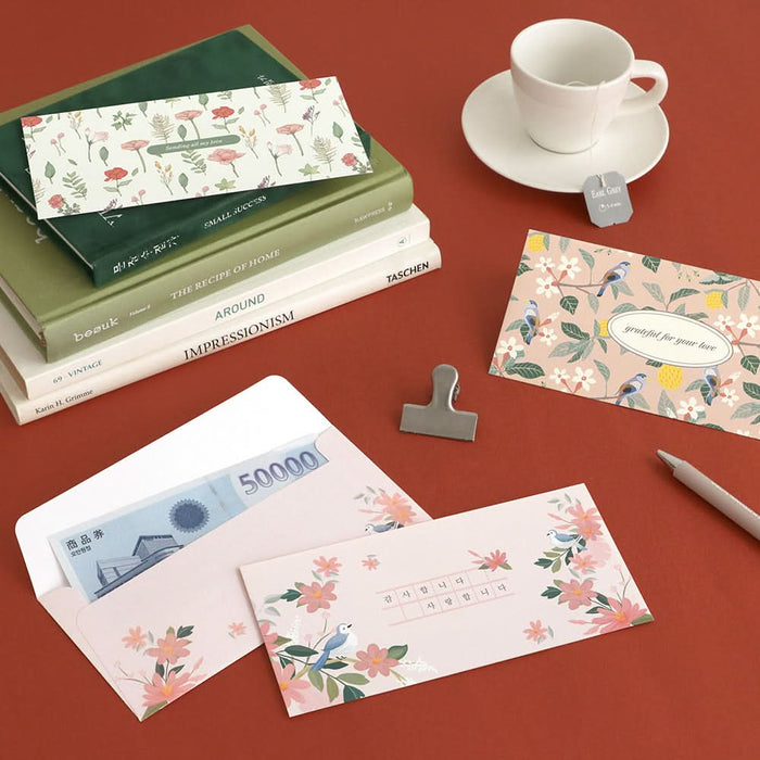 The Journal Shop - Assorted Iconic Fortune Envelopes in botanical and pastel themed prints laid out beside notebooks and a teacup.