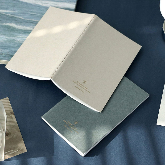 Iconic Haze pocket notebook displayed with books and stationeries.