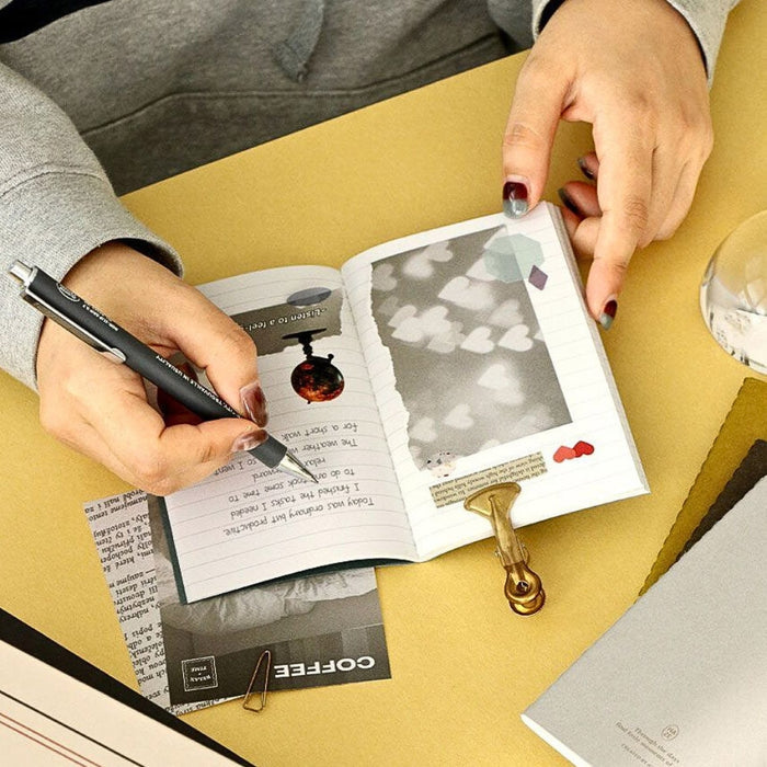 Hands writing notes inside Iconic Haze pocket notebook with lined pages.