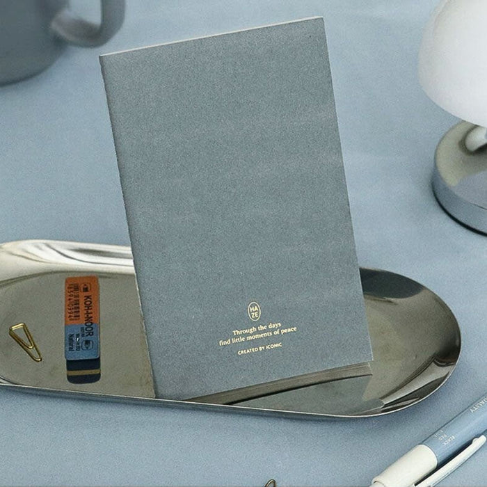 Iconic Haze pocket notebook styled with tray and small desk items.