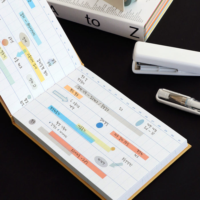 Planner spread featuring Iconic Index Long Highlighter POP tabs and a pen on the page.