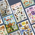 The Journal Shop - Collection of Iconic Just Object Sticker sheets featuring assorted realistic and illustrated designs laid out on a desk.