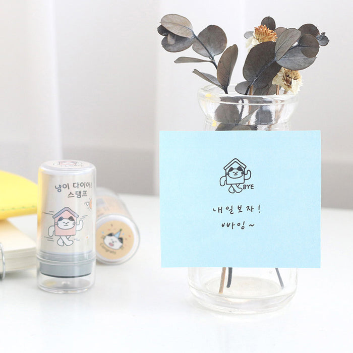 The Journal Shop - Blue Meow Self Inking Stamp used to mark a note on a desk beside stationery and organisers.
