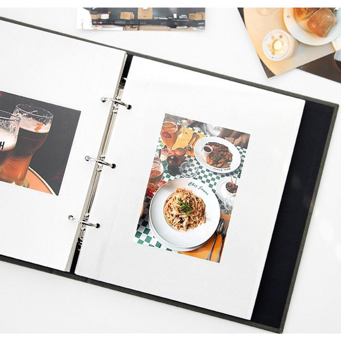 The Journal Shop - Open scrapbook binder displaying neatly arranged photo prints and mementoes in clear pockets.