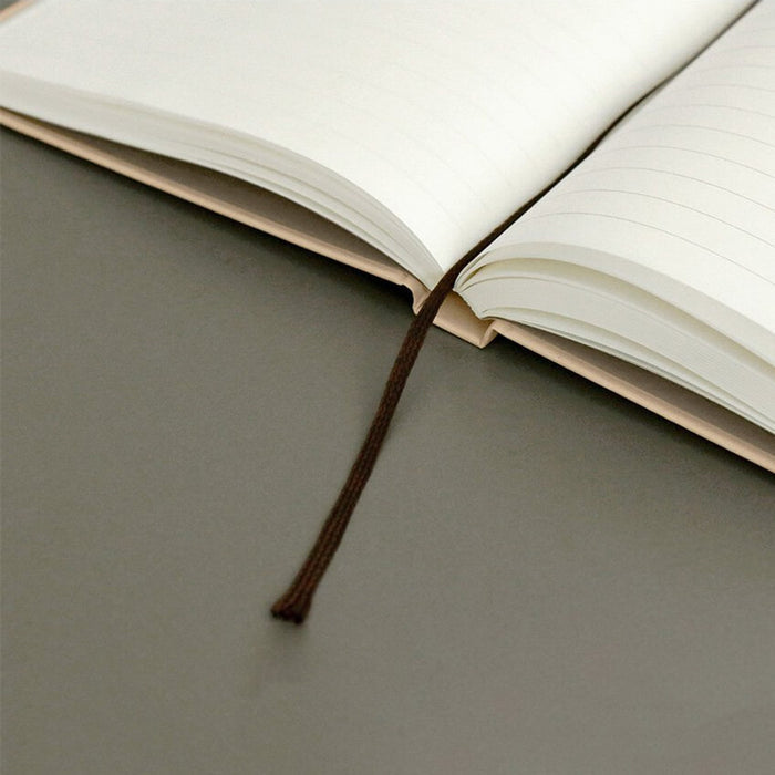The Journal Shop - Iconic Solitude Tomoe River Line Notebook open flat with brown ribbon bookmark visible.