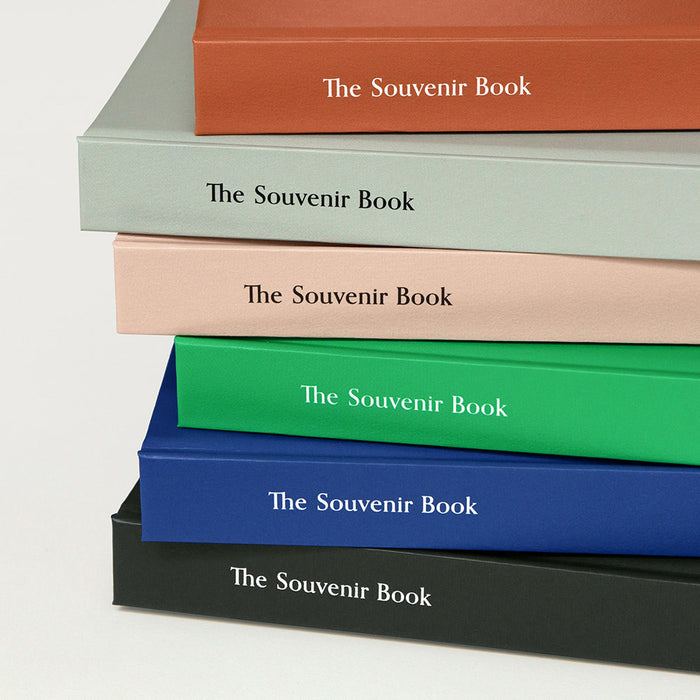 The Journal Shop - A close-up of stacked Iconic Souvenir B6 Grid Notebooks in assorted colours showing their elegant spines with embossed titles.