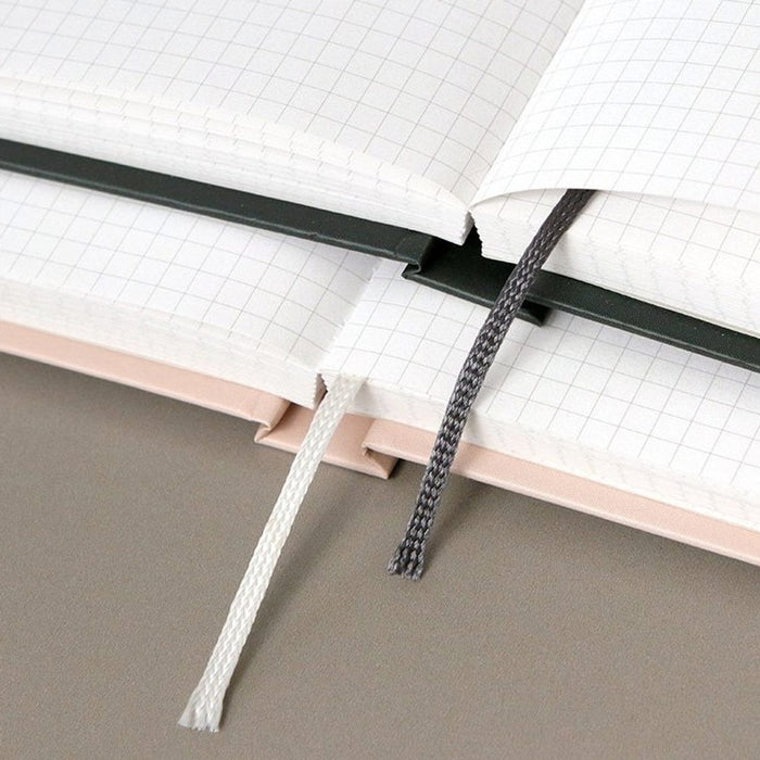 The Journal Shop - Two open Iconic Souvenir B6 Grid Notebooks arranged on a desk, showcasing the light grid paper and smooth binding.
