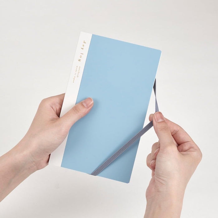 Hand holding the blue Daigo Isshoni Day Log B6 Slim Notebook.