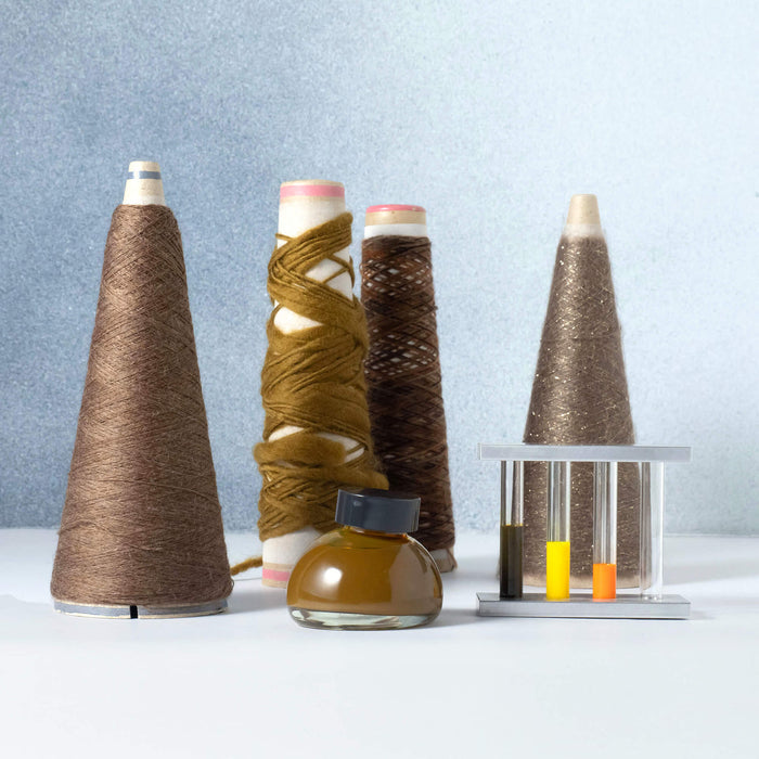 The Journal Shop - Kakimori Colour Specimen Ink bottles displayed with yarn cones and test tubes, inspired by textile ink 202.