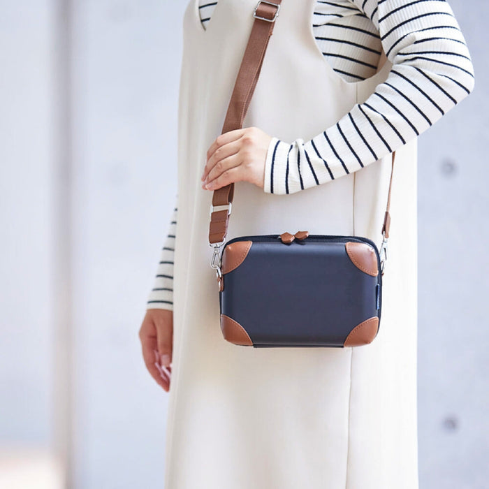 Carchette carrying pouch worn crossbody with adjustable shoulder strap.