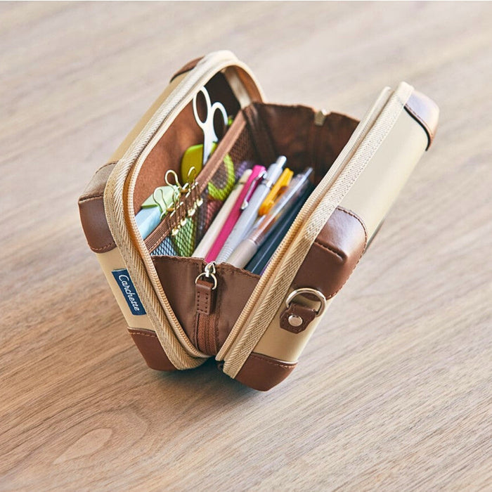 Open Carchette carrying pouch filled with pens, notebooks, and daily essentials.