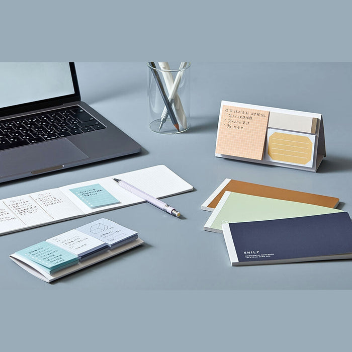EMILY Fusen sticky notes arranged on a desk with notebook, pen and workspace accessories.