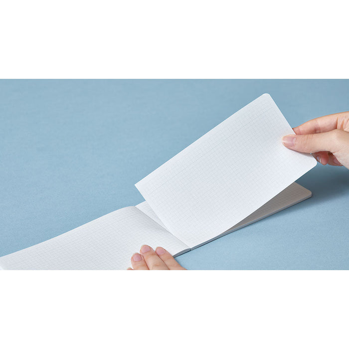 Hand opening an EMILY horizontal notebook to reveal smooth interior pages