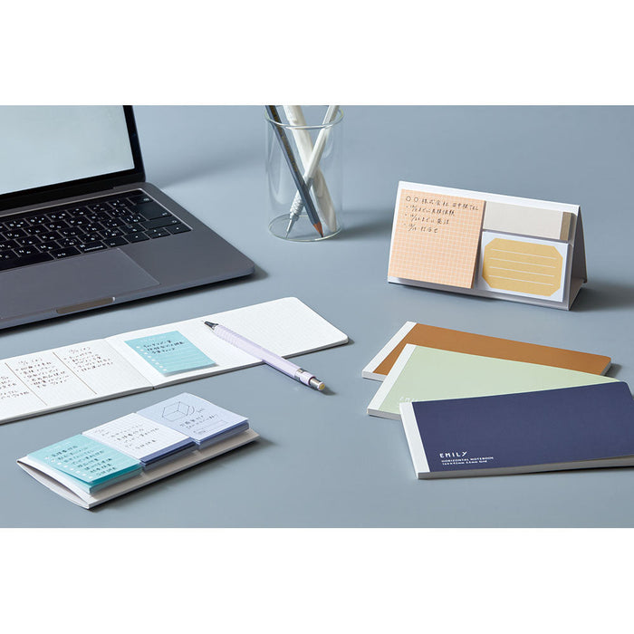 EMILY horizontal notebooks arranged with stationery in a flat lay style.