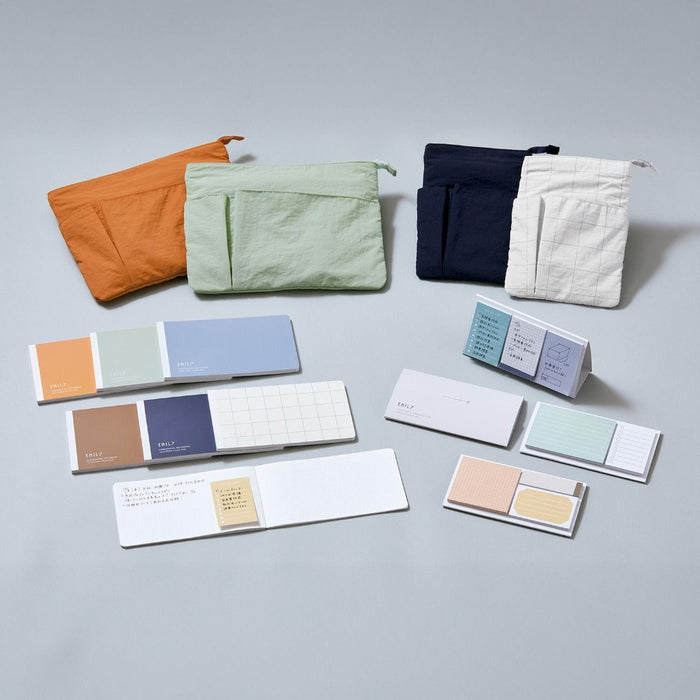 Assorted EMILY work pouches displayed in multiple colours alongside notebooks and stationery in a flat lay.