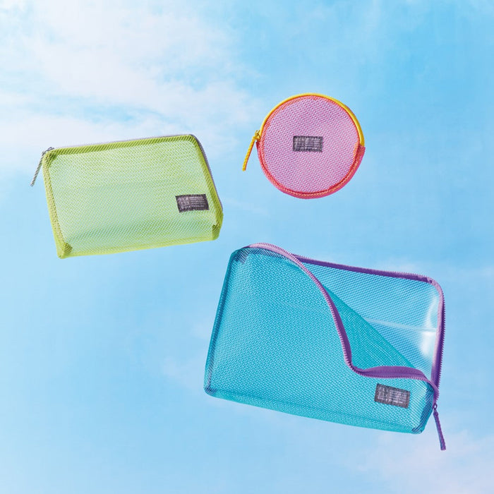Flatty Sheer transparent pouches in green, blue and pink displayed on a sky blue background.
