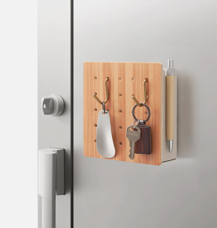 Harupeggy small pegboard mounted on a door, holding keys, stationery and small accessories.