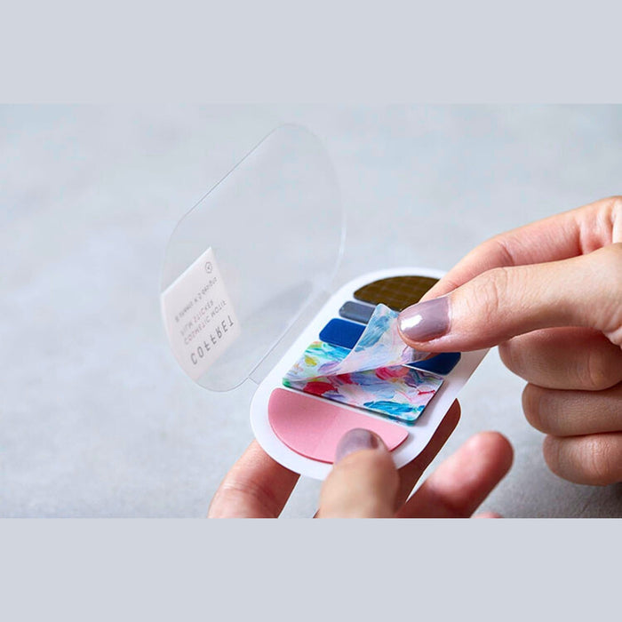 Hands using tweezers to apply a COFFRET cosmetic motif film sticker.