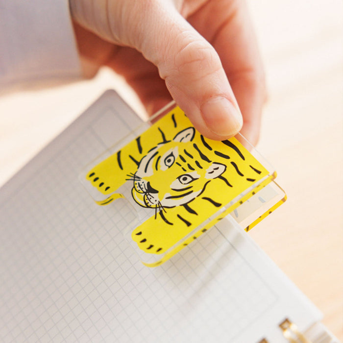 A hand putting a clip to a HITOTOKI comic size ring notebook.