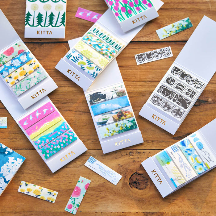 Flat lay of KITTA Basic Washi Stickers showing multiple patterned sticker packs on a wooden surface.