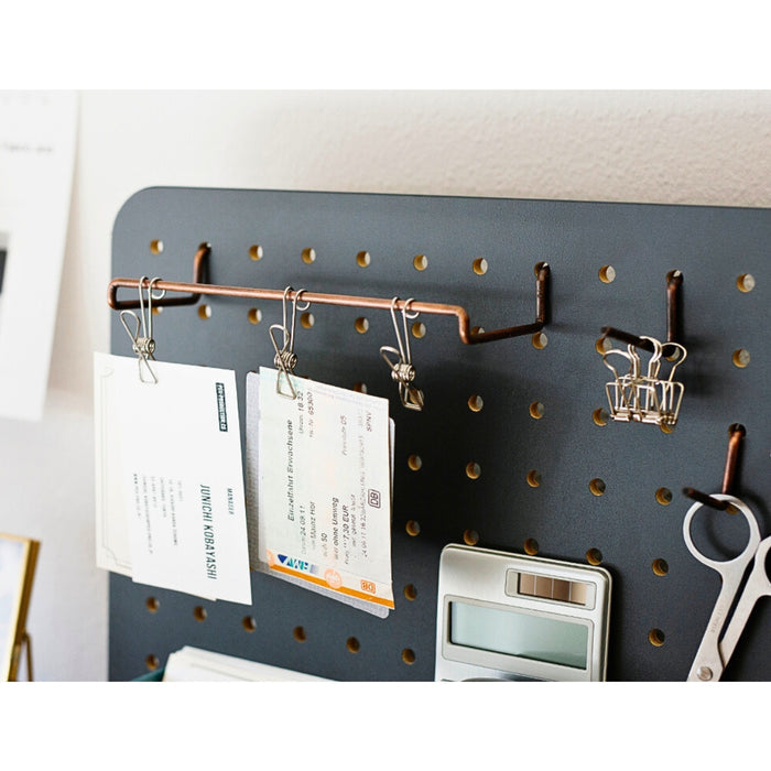 Black PEGGY pegboard stand holding hooks and organisers for desk storage.
