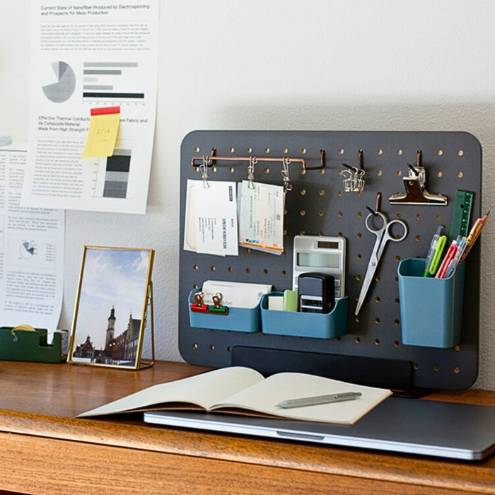 PEGGY black pegboard stand used as a workspace organiser with notes and tools.