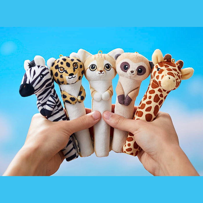 Hand holding multiple Pouzoo animal pen grips including giraffe, zebra and leopard designs.