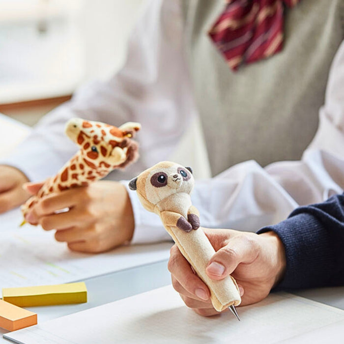Giraffe and Meerkat Pouzoo pen grip used at a desk for everyday writing.