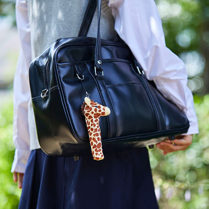 Giraffe Pouzoo pen grip attached to a pen clipped onto a handbag.