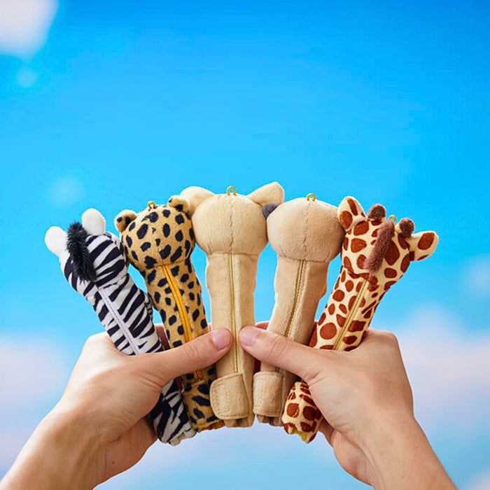 Pouzoo animal pen grips held outdoors against a blue sky background.