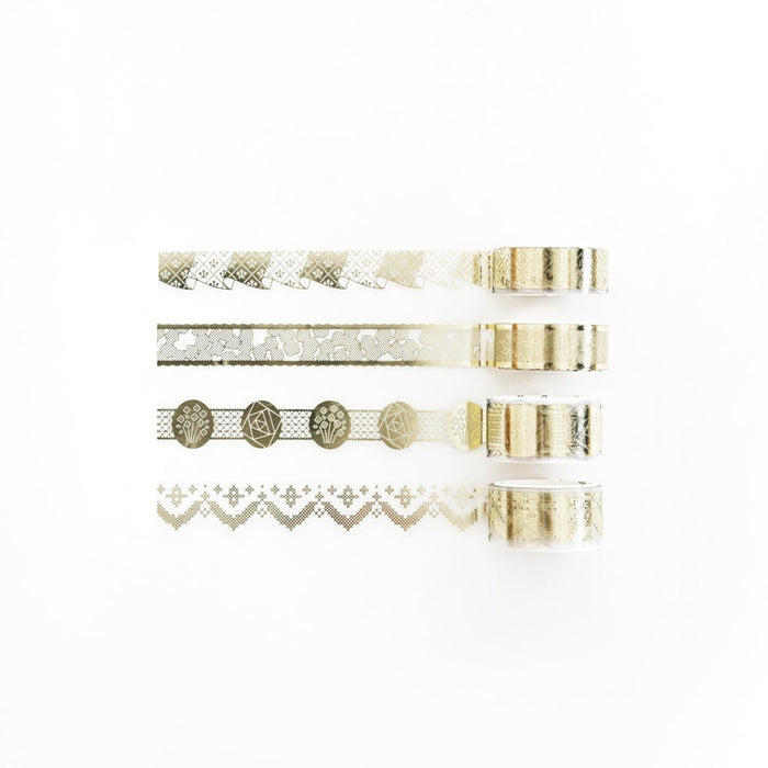 Decorative foil and die-cut masking tape strips laid out in repeating patterns.