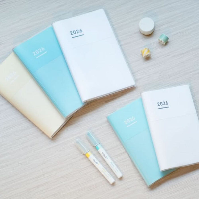 Kokuyo Jibun Techo Diary 2026 A5 Slim Planners in pastel covers styled on a desk with pens and accessories.