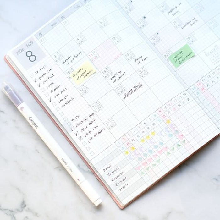 Person writing in Kokuyo Jibun Techo Lite 2026 Mini B6 Slim Diary, showing practical use at a desk.