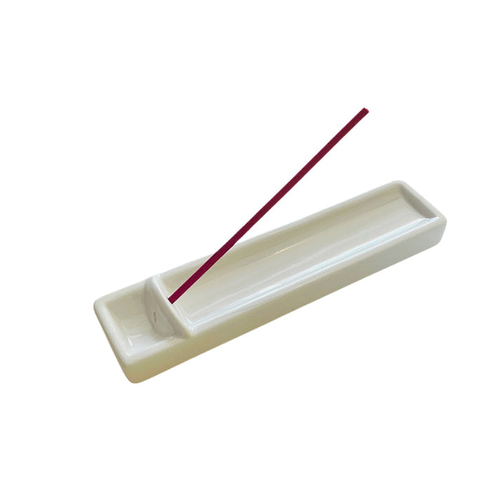 Kousaido milky white long incense dish holding a single incense stick during use.