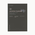 Black cover of the L.C.C Monthly Planner notebook featuring minimalist layout and soft-textured design