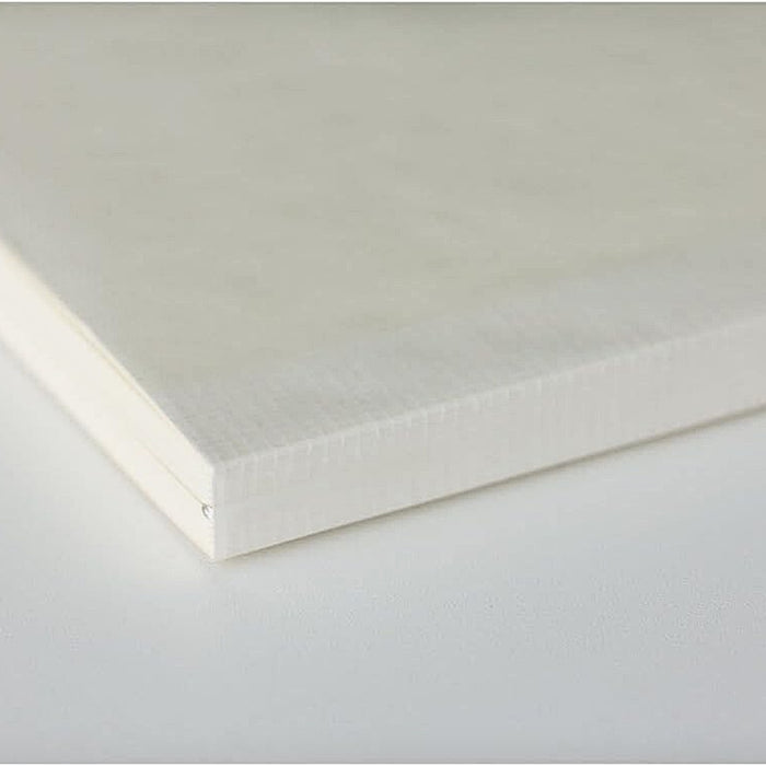 Stacked Midori MD Paper Notebook A5 Grid closed, highlighting thread binding and smooth paper edges