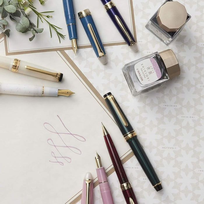 Sailor Shikiori Long Night fountain pen styled with writing tools and stationery on a desk.